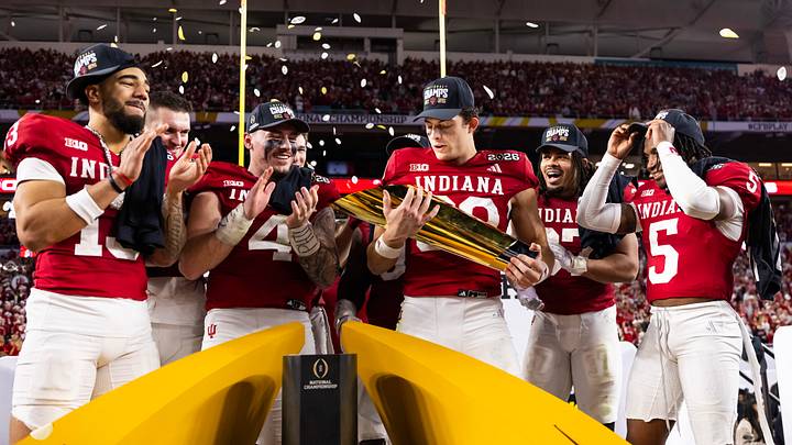 Jan 19, 2026; Miami Gardens, FL, USA; Indiana Hoosiers wide receiver Charlie Becker (80) celebrates with the trophy  with teammates wide receiver Elijah Sarratt (13) linebacker Aiden Fisher (4) tight end Riley Nowakowski (37) celebrates after defeating the Miami Hurricanes in the College Football Playoff National Championship game at Hard Rock Stadium. Mandatory Credit: Mark J. Rebilas-Imagn Images
