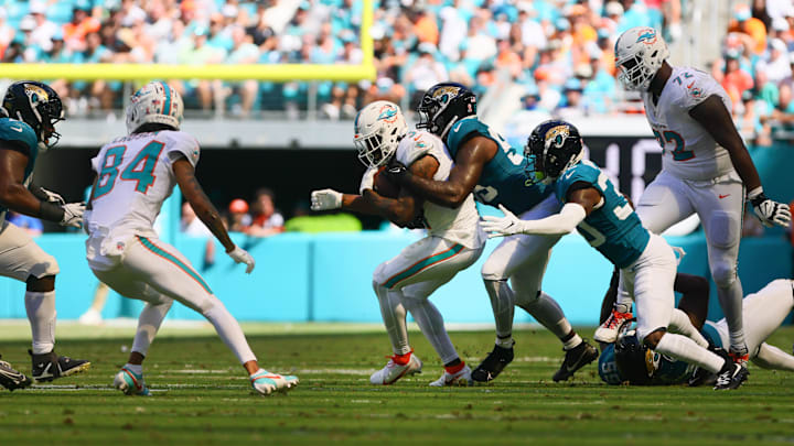 Miami Dolphins running back Raheem Mostert (31) runs with the football against Jacksonville Jaguars linebacker Yasir Abdullah (56) and cornerback Montaric Brown (30) during the fourth quarter at Hard Rock Stadium in the season opener.