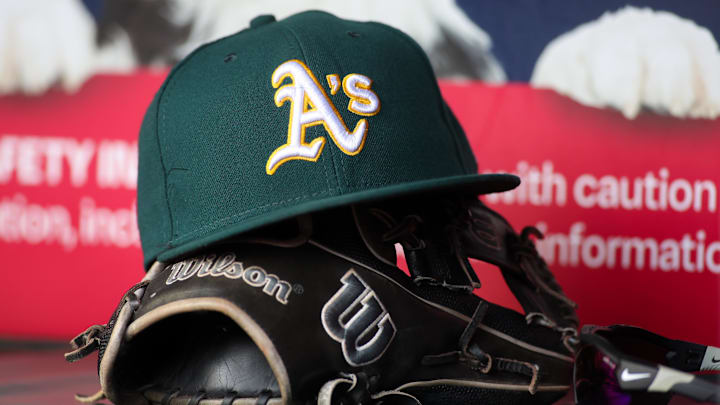 Jun 1, 2024; Atlanta, Georgia, USA; A detailed view of an Oakland Athletics hat and glove on the field against the Atlanta Braves in the sixth inning at Truist Park. Mandatory Credit: Brett Davis-Imagn Images