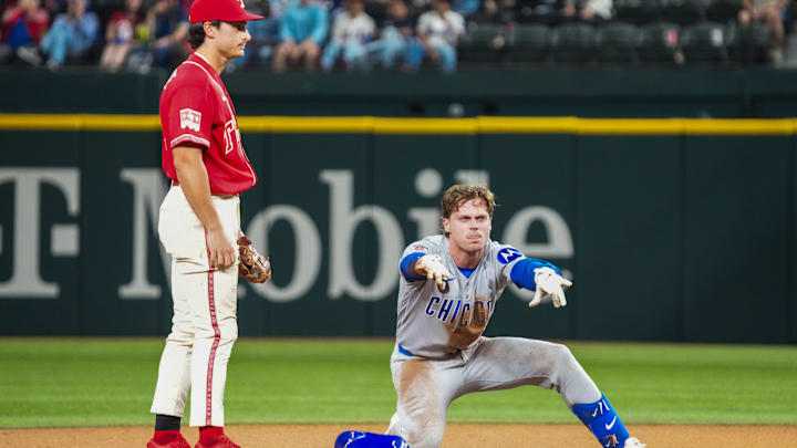 May 8, 2026; Arlington, Texas, USA;  Chicago Cubs second baseman Nico Hoerner (2) reacts towards the dugout after advancing to second on a two-base error during the seventh inning as Texas Rangers first baseman Justin Foscue (14) looks on at Globe Life Field. Mandatory Credit: Raymond Carlin III-Imagn Images