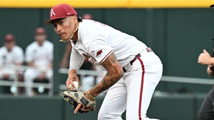 Jun 17, 2025; Omaha, Neb, USA;  Arkansas Razorbacks shortstop Wehiwa Aloy (9) fields a ground ball against the UCLA Bruins during the sixth inning at Charles Schwab Field. 
