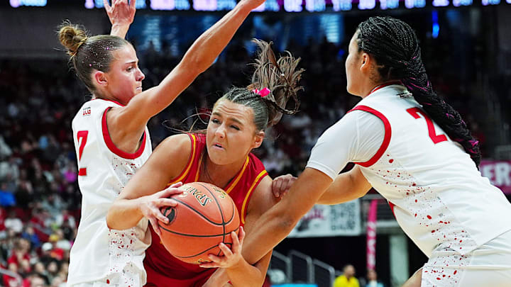 Carlisle Macy Comito (23) drives with the ball between Dallas Center-Grimes guard Leah Brauch (2) and forward Aniyah Boens (20) during the second quarter in the 4A girls high school state basketball championship game on March 7, 2026, at Casey’s Center in Des Moines, Iowa.