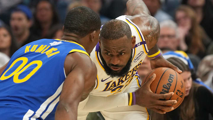 Dec 25, 2024; San Francisco, California, USA; Los Angeles Lakers forward LeBron James (right) handles the ball against Golden State Warriors forward Jonathan Kuminga (00) during the second quarter at Chase Center. Mandatory Credit: Darren Yamashita-Imagn Images