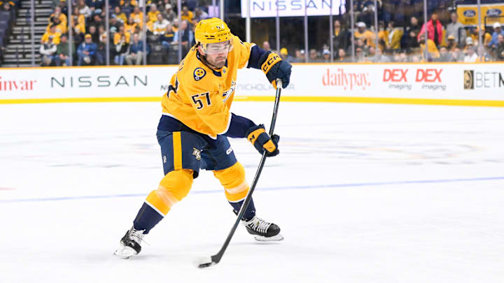 Oct 15, 2024; Nashville, Tennessee, USA;  Nashville Predators defenseman Dante Fabbro (57) takes a shot on goal against the Seattle Kraken during the first period at Bridgestone Arena. Mandatory Credit: Steve Roberts-Imagn Images
