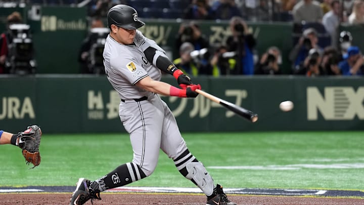 Mar 16, 2025; Bunkyo, Tokyo, Japan; Yomiuri Giants first baseman Kazuma Okamoto (25) hits a single against the Chicago Cubs during the second inning at Tokyo Dome. Mandatory Credit: Darren Yamashita-Imagn Images