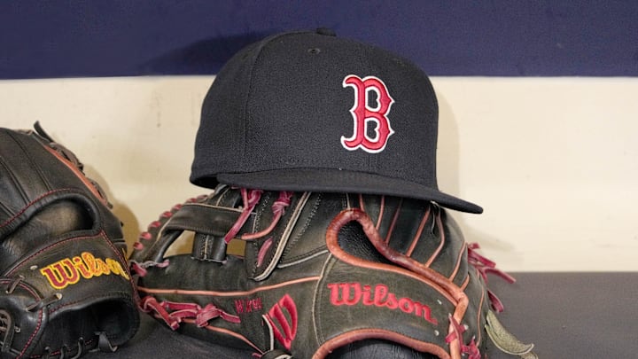 May 27, 2025; Milwaukee, Wisconsin, USA; A Boston Red Sox hat and glove sit in the dug out before a game against the Milwaukee Brewers at American Family Field. Mandatory Credit: Michael McLoone-Imagn Images