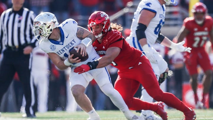 Louisville Cardinals defensive lineman Ashton Gillotte (9) brings down Kentucky Wildcats quarterback Devin Leary (13) for a sack in the first half Saturday. Nov. 25, 2023.