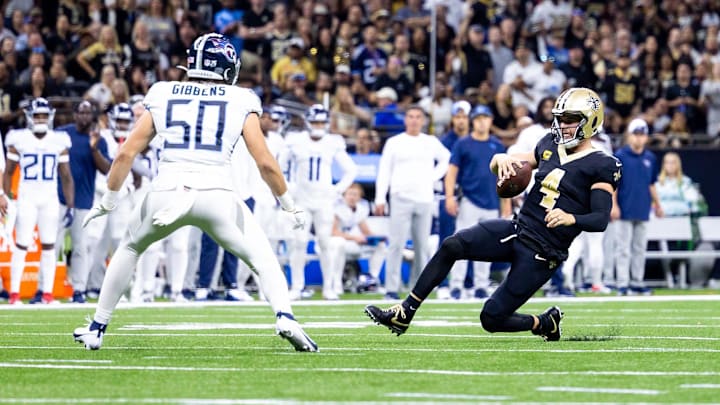 Sep 10, 2023; New Orleans, Louisiana, USA;  New Orleans Saints quarterback Derek Carr (4) slides to avoid the tackle of Tennessee Titans linebacker Jack Gibbens (50) during the first half at the Caesars Superdome. Mandatory Credit: Stephen Lew-Imagn Images