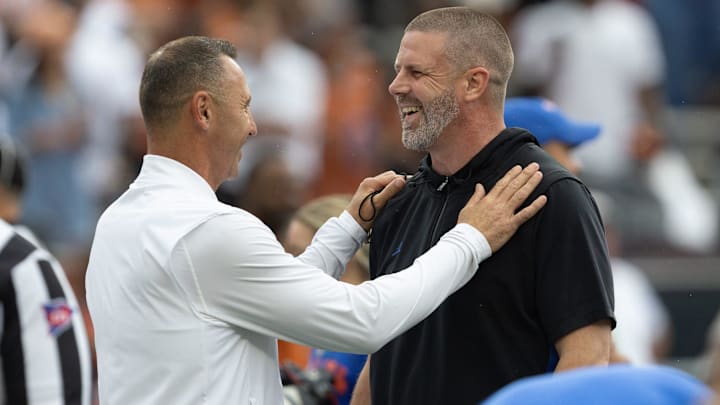 Texas head coach Steve Sarkisian, left, and Florida head coach Billy Napier meet at midfield before a game in Gainesville, FL