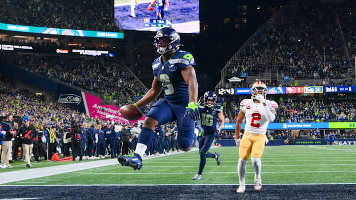 Jan 17, 2026; Seattle, WA, USA; Seattle Seahawks running back Kenneth Walker III (9) carries the ball for a touchdown as San Francisco 49ers cornerback Deommodore Lenoir (2) trails on the play during the second half in an NFC Divisional Round game at Lumen Field. Mandatory Credit: Steven Bisig-Imagn Images