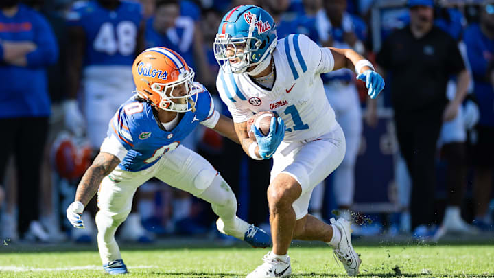 Nov 23, 2024; Gainesville, Florida, USA; Mississippi Rebels wide receiver Jordan Watkins (11) rushes with the ball past Florida Gators defensive back Sharif Denson (0) during the second half at Ben Hill Griffin Stadium. 