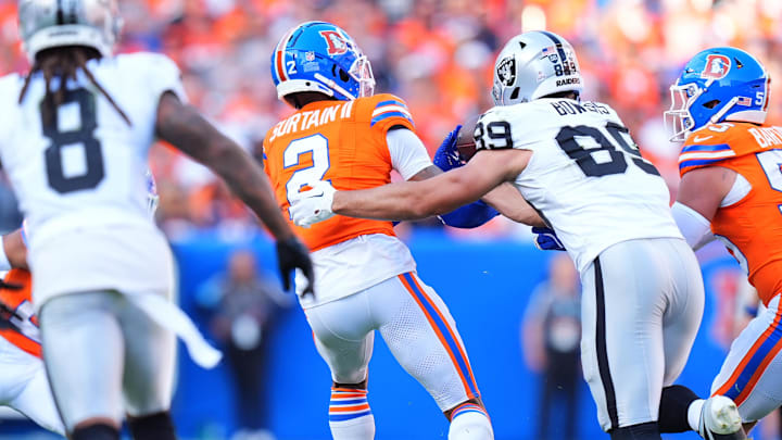 Oct 6, 2024; Denver, Colorado, USA; Denver Broncos cornerback Pat Surtain II (2) brings in a interception away from Las Vegas Raiders tight end Brock Bowers (89) in the fourth quarter at Empower Field at Mile High. 