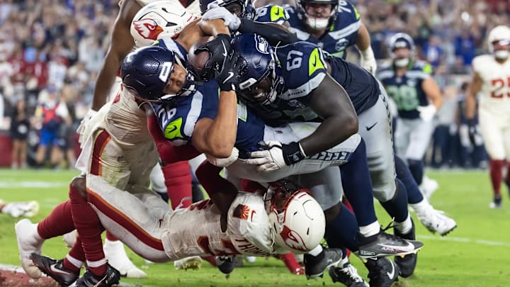 Sep 25, 2025; Glendale, Arizona, USA; Seattle Seahawks running back Zach Charbonnet (26) is pushed across the goal line by tackle Charles Cross (67) to score a touchdown against Arizona Cardinals safety Jalen Thompson (34) in the second quarter at State Farm Stadium. Mandatory Credit: Mark J. Rebilas-Imagn Images Sep 25, 2025; Glendale, Arizona, USA; Seattle Seahawks running back Zach Charbonnet (26) is pushed across the goal line by tackle Charles Cross (67) to score a touchdown against Arizona Cardinals safety Jalen Thompson (34) in the second quarter at State Farm Stadium. Mandatory Credit: Mark J. Rebilas-Imagn Images