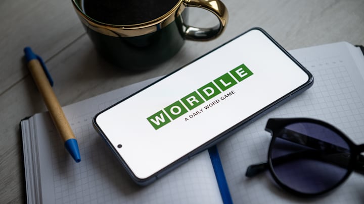 Photo of a phone with a "wordle" logo next to a mug and notebook