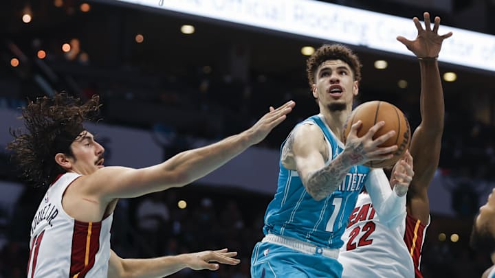 Oct 26, 2024; Charlotte, North Carolina, USA; Charlotte Hornets guard LaMelo Ball (1) drives to the basket against Miami Heat guard Jaime Jaquez Jr. (11) and forward Jimmy Butler (22) during the second half at Spectrum Center. Mandatory Credit: Nell Redmond-Imagn Images