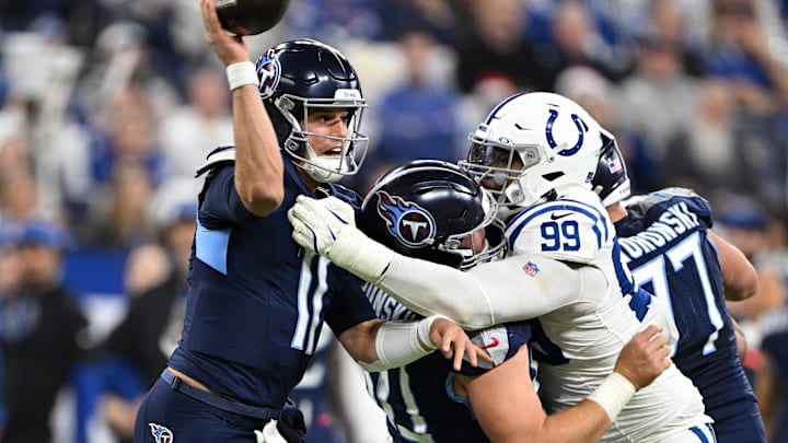 Dec 22, 2024; Indianapolis, Indiana, USA;  Tennessee Titans quarterback Mason Rudolph (11) throws the ball before being hit by Indianapolis Colts defensive tackle DeForest Buckner (99) during the second quarter at Lucas Oil Stadium. Mandatory Credit: Marc Lebryk-Imagn Images