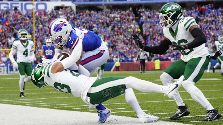 Dec 29, 2024; Orchard Park, New York, USA; New York Jets cornerback Isaiah Oliver (23) tackles Buffalo Bills wide receiver Keon Coleman (0) during the first half at Highmark Stadium. 