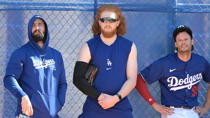 Feb 18, 2024; Glendale, AZ, USA;  Los Angeles Dodgers starting pitcher Tony Gonsolin (26), starting pitcher Dustin May (85) and relief pitcher Joe Kelly (99) lean on a fence in the bull pen during spring training at Camelback Ranch. Mandatory Credit: Jayne Kamin-Oncea-USA TODAY Sports