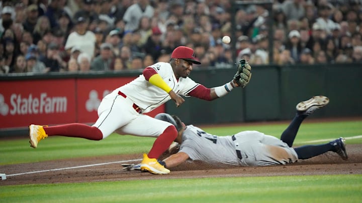 New York Yankees base runner Anthony Volpe (11) slides into third as the throw gets past Arizona Diamondbacks third baseman Eugenio Suarez (28) during the third inning at Chase Field.