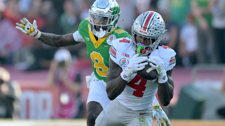 Jan 1, 2025; Pasadena, CA, USA; Ohio State Buckeyes wide receiver Jeremiah Smith (4) makes a catch against Oregon Ducks defensive back Dontae Manning (8) in the first quarter in the 2025 Rose Bowl college football quarterfinal game at Rose Bowl Stadium. Mandatory Credit: Jayne Kamin-Oncea-Imagn Images