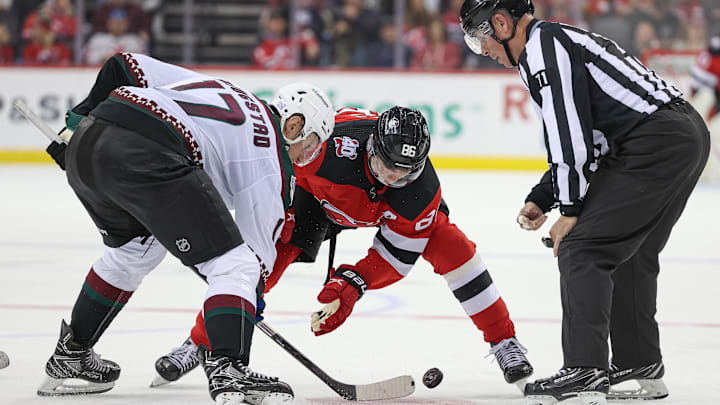 Arizona Coyotes center Nick Bjugstad (17) faces off against New Jersey Devils center Jack Hughes (86): Vincent Carchietta-Imagn Images