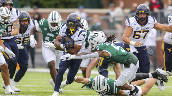 Sep 6, 2025; Athens, Ohio, USA; West Virginia Mountaineers running back Jahiem White (1) runs the ball and is tackled by Ohio Bobcats safety Adonis Williams Jr. (5) during the first quarter at Peden Stadium. Mandatory Credit: Ben Queen-Imagn Images