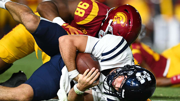 Sep 7, 2024; Los Angeles, California, USA; USC Trojans defensive end Devan Thompkins (98) sacks Utah State Aggies quarterback Bryson Barnes (16) during the third quarter at United Airlines Field at Los Angeles Memorial Coliseum. Mandatory Credit: Jonathan Hui-Imagn Images