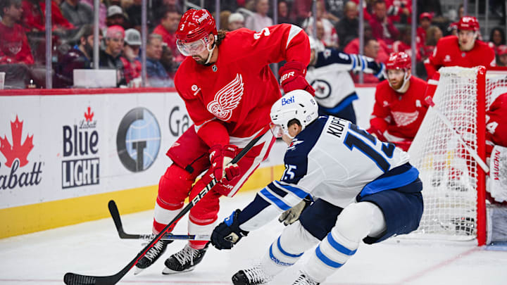 Oct 30, 2024; Detroit, Michigan, USA; Detroit Red Wings defenseman Justin Holl (3) and Winnipeg Jets center Rasmus Kupari (15) battle for the puck during the game at Little Caesars Arena. Mandatory Credit: Tim Fuller-Imagn Images
