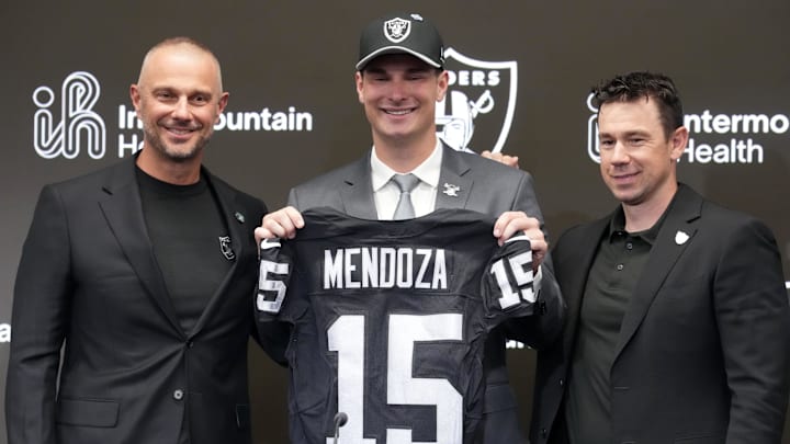 Apr 24, 2026; Henderson, NV, USA; Las Vegas Raiders quarterback Fernando Mendoza (center) poses with jersey at introductory press conference at Intermountain Health Performance Center flanked by general manager John Spytek (left) and head coach Klint Kubiak after being selected as the No. 1 pick in the 2026 NFL Draft. Mandatory Credit: Kirby Lee-Imagn Images