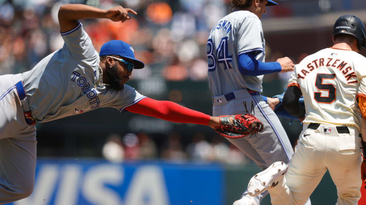 Jul 11, 2024; San Francisco, California, USA; Toronto Blue Jays first base Vladimir Guerrero Jr. (27) dives to tag San Francisco Giants outfielder Mike Yastrzemski (5) during the fourth inning at Oracle Park. 