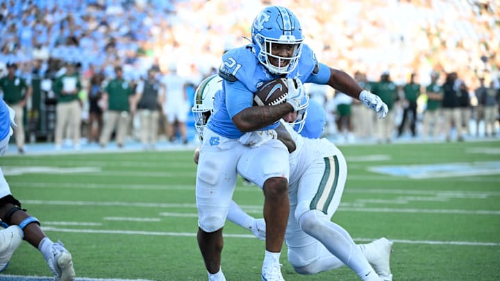 Sep 7, 2024; Chapel Hill, North Carolina, USA; North Carolina Tar Heels running back Davion Gause (21) scores a touchdown as Charlotte 49ers defensive lineman Chantz Williams (14) defends in the fourth quarter at Kenan Memorial Stadium. Mandatory Credit: Bob Donnan-Imagn Images