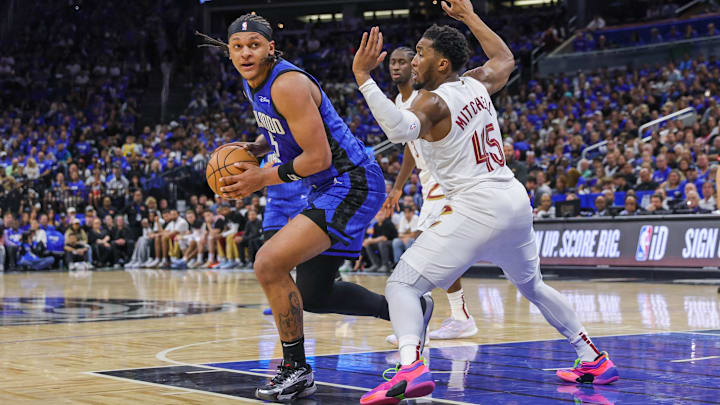 Apr 25, 2024; Orlando, Florida, USA; Orlando Magic forward Paolo Banchero (5) controls the ball in front of Cleveland Cavaliers guard Donovan Mitchell (45) during the second quarter of game three of the first round for the 2024 NBA playoffs at Kia Center. Mandatory Credit: Mike Watters-Imagn Images