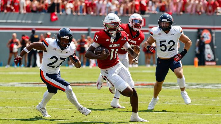 Sep 6, 2025; Raleigh, North Carolina, USA; North Carolina State Wolfpack quarterback CJ Bailey (11) runs with the football guarded by Virginia Cavaliers safety Devin Neal (27) during the first half of the game at Carter-Finley Stadium. Mandatory Credit: Jaylynn Nash-Imagn Images Sep 6, 2025; Raleigh, North Carolina, USA; North Carolina State Wolfpack quarterback CJ Bailey (11) runs with the football guarded by Virginia Cavaliers safety Devin Neal (27) during the first half of the game at Carter-Finley Stadium. Mandatory Credit: Jaylynn Nash-Imagn Images
