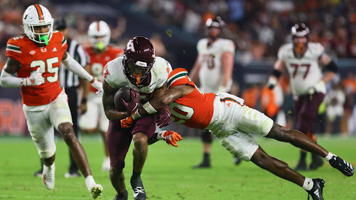 Sep 27, 2024; Miami Gardens, Florida, USA; Virginia Tech Hokies running back Bhayshul Tuten (33) runs with the football against Miami Hurricanes defensive back Zaquan Patterson (20) during the fourth quarter at Hard Rock Stadium. Mandatory Credit: Sam Navarro-Imagn Images