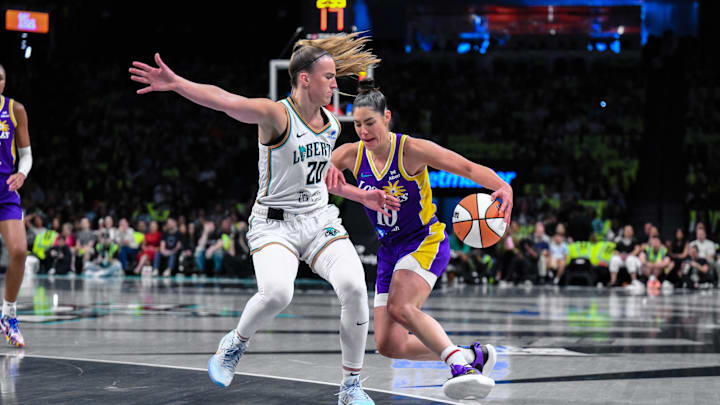Jul 26, 2025; Brooklyn, New York, USA; Los Angeles Sparks guard Kelsey Plum (10) drives to the basket as New York Liberty guard Sabrina Ionescu (20) defends during the first half at Barclays Center. Mandatory Credit: John Jones-Imagn Images