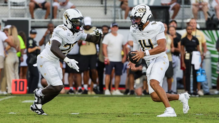 Aug 28, 2025; Orlando, Florida, USA; UCF Knights quarterback Cam Fancher (14) fakes a handoff to running back Myles Montgomery (22) during the first quarter at Acrisure Bounce House. Mandatory Credit: Mike Watters-Imagn Images