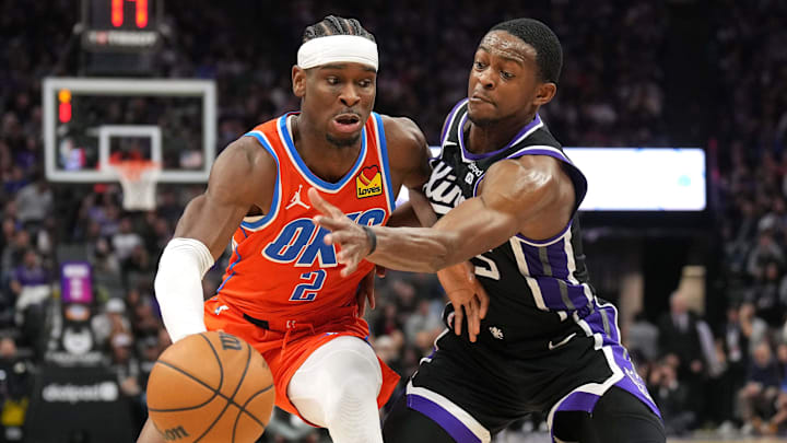 Dec 14, 2023; Sacramento, California, USA; Oklahoma City Thunder guard Shai Gilgeous-Alexander (2) dribbles against Sacramento Kings guard De'Aaron Fox (right) during the fourth quarter at Golden 1 Center. Mandatory Credit: Darren Yamashita-Imagn Images