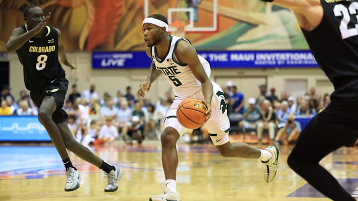 Nov 25, 2024; Lahaina, Hawaii, USA; Michigan State Spartans guard Tre Holloman (5) is defended by Colorado Buffaloes forward Bangot Dak (8) in the first half of an NCAA college basketball game at Lahaina Civic Center. Mandatory Credit: Marco Garcia-Imagn Images