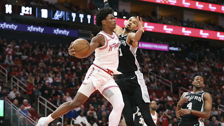 Jan 28, 2026; Houston, Texas, USA; Houston Rockets guard Amen Thompson (1) passes the ball around San Antonio Spurs forward Victor Wembanyama (1) during the first quarter at Toyota Center. Mandatory Credit: Troy Taormina-Imagn Images