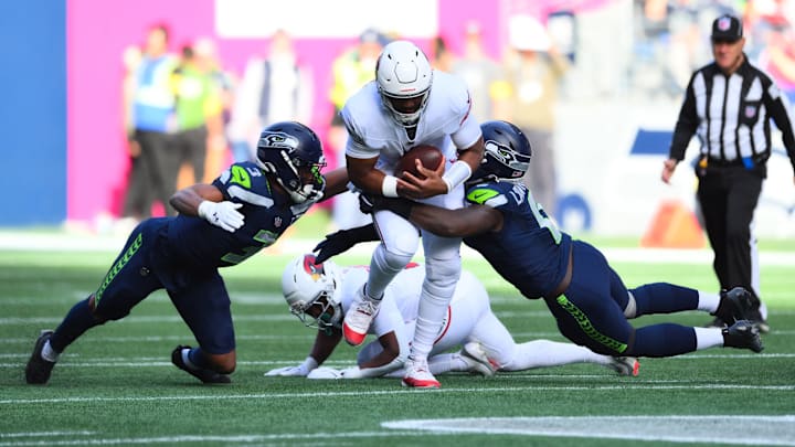 Nov 9, 2025; Seattle, Washington, USA; Arizona Cardinals quarterback Jacoby Brissett (7) is sacked by Seattle Seahawks safety Nick Emmanwori (3) and Seattle Seahawks defensive end DeMarcus Lawrence (0) during the second quarter at Lumen Field.