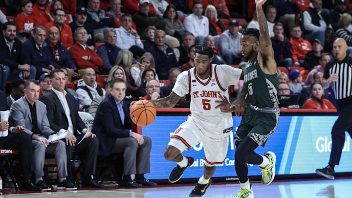 Nov 13, 2024; Queens, New York, USA;  St. John's basketball guard Deivon Smith (5) drives past Wagner Seahawks guard Zae Blake (5) in the second half at Carnesecca Arena.