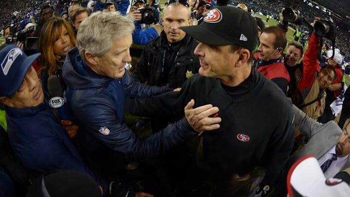 Jan 19, 2014; Seattle, WA, USA; Seattle Seahawks head coach Pete Carroll (left) shakes hands with San Francisco 49ers head coach Jim Harbaugh (right) after the 2013 NFC Championship football game at CenturyLink Field. Mandatory Credit: Kirby Lee-Imagn Images