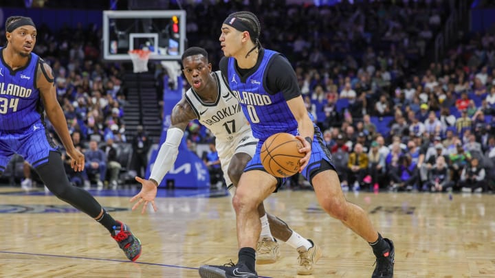 Feb 27, 2024; Orlando, Florida, USA; Orlando Magic guard Anthony Black (0) drives around Brooklyn Nets guard Dennis Schroder (17) during the second quarter at Amway Center. 