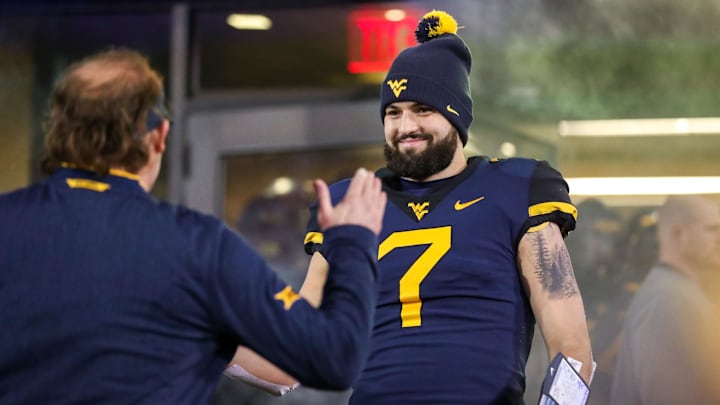 Nov 23, 2018; Morgantown, WV, USA; West Virginia Mountaineers quarterback Will Grier (7) hugs West Virginia Mountaineers head coach Dana Holgorsen during senior night activities before their game against the Oklahoma Sooners at Mountaineer Field at Milan Puskar Stadium. Mandatory Credit: Ben Queen-Imagn Images