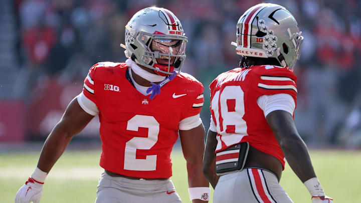 Nov 22, 2025; Columbus, Ohio, USA; Ohio State Buckeyes safeties Caleb Downs (2) and Jaylen McClain (18) celebrate a defensive stop on fourth down against the Rutgers Scarlet Knights during the first quarter at Ohio Stadium. Mandatory Credit: Joseph Maiorana-Imagn Images