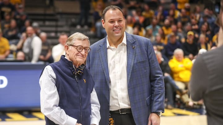 Dec 18, 2022; Morgantown, West Virginia, USA; West Virginia University President Gordon Gee welcomes new West Virginia Mountaineers Athletic Director Wren Baker during the first half against the Buffalo Bulls at WVU Coliseum. Mandatory Credit: Ben Queen-Imagn Images