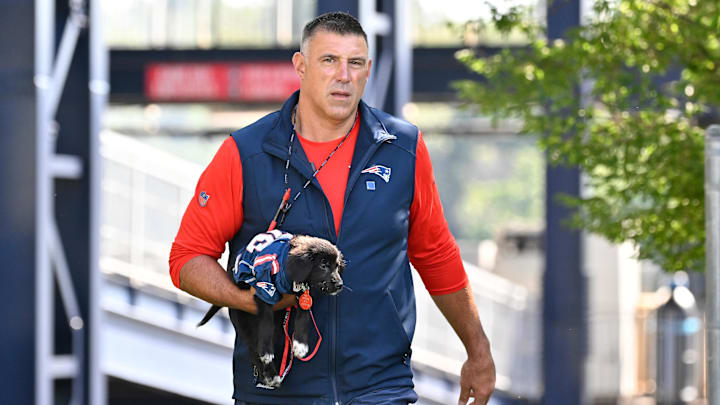 Jul 23, 2025; Foxborough, MA, USA; New England Patriots head coach Mike Vrabel delivers a puppy to a local family before addressing the media during training camp at Gillette Stadium. Mandatory Credit: Eric Canha-Imagn Images