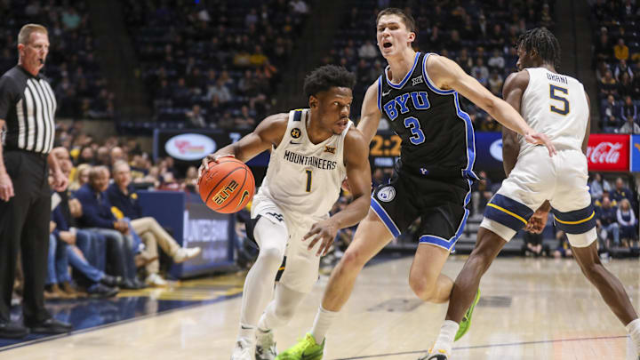 Feb 11, 2025; Morgantown, West Virginia, USA; West Virginia Mountaineers guard Joseph Yesufu (1) dribbles past Brigham Young Cougars guard Egor Demin (3) during the first half at WVU Coliseum. Mandatory Credit: Ben Queen-Imagn Images