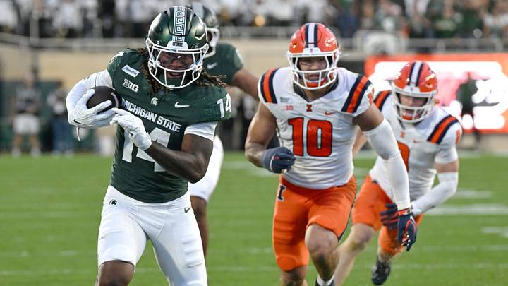 Oct 10, 2026; East Lansing, Michigan, USA;  Michigan State Spartans wide receiver Bryson Williams (14) runs past Illinois Fighting Illini linebacker James Kreutz (10) during the fourth quarter at Spartan Stadium.  Mandatory Credit: Dale Young-Imagn Images