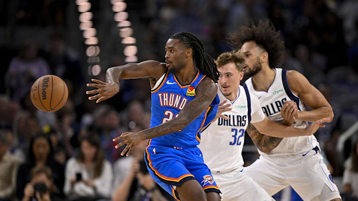 Oct 6, 2025; Fort Worth, Texas, USA; Oklahoma City Thunder guard Cason Wallace (22) passes the ball by Dallas Mavericks forward Cooper Flagg (32) and center Dereck Lively II (2) during the first quarter at Dickie's Arena. Mandatory Credit: Jerome Miron-Imagn Images